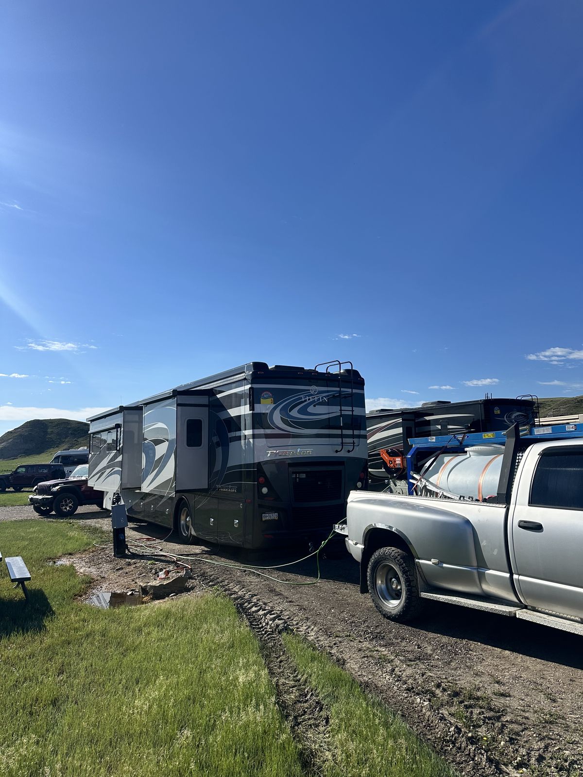 Class A motorhomes being detailed on-site with the mobile water truck